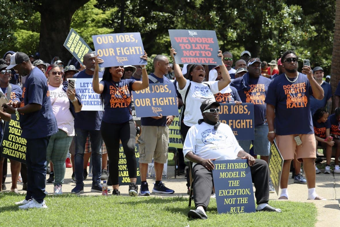 Workers hold signs supporting labor organizers
