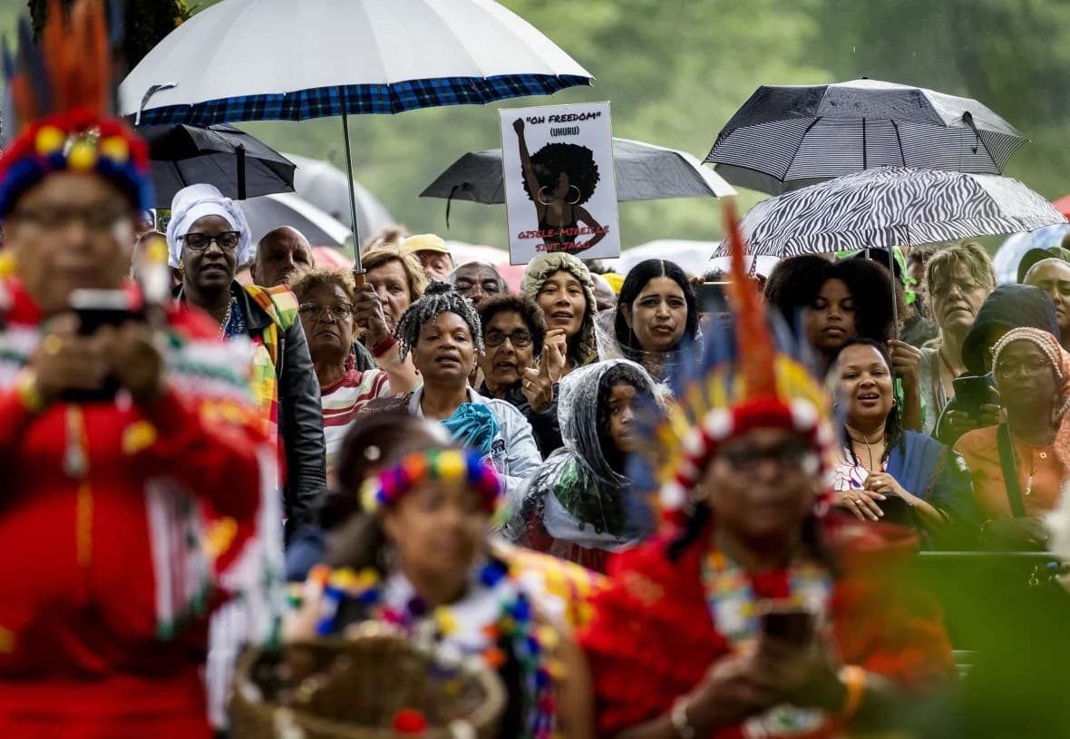 Onlookers surround the slavery monument in the Netherlands