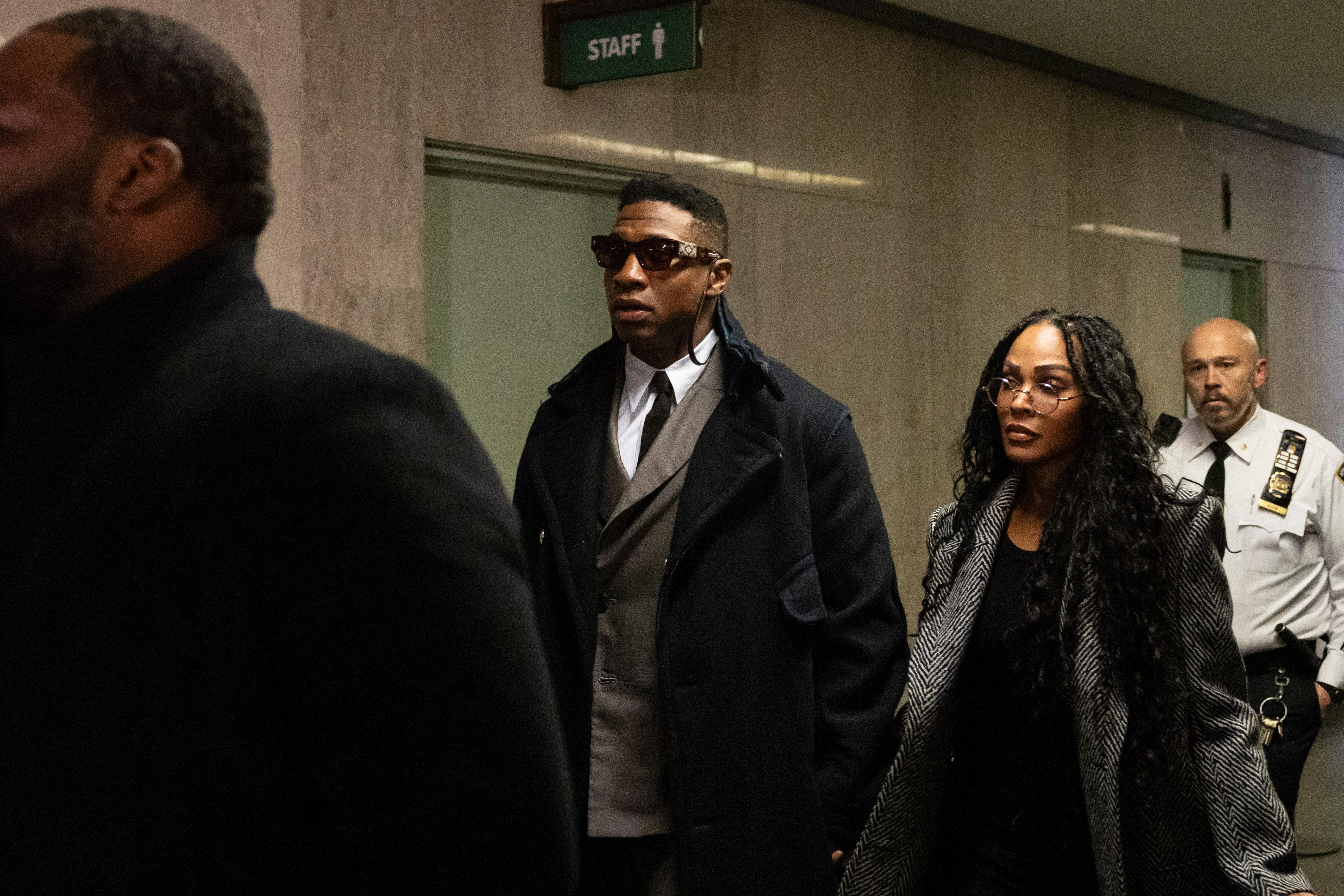 Actors Jonathan Majors, center, and Meagan Good arrive at court