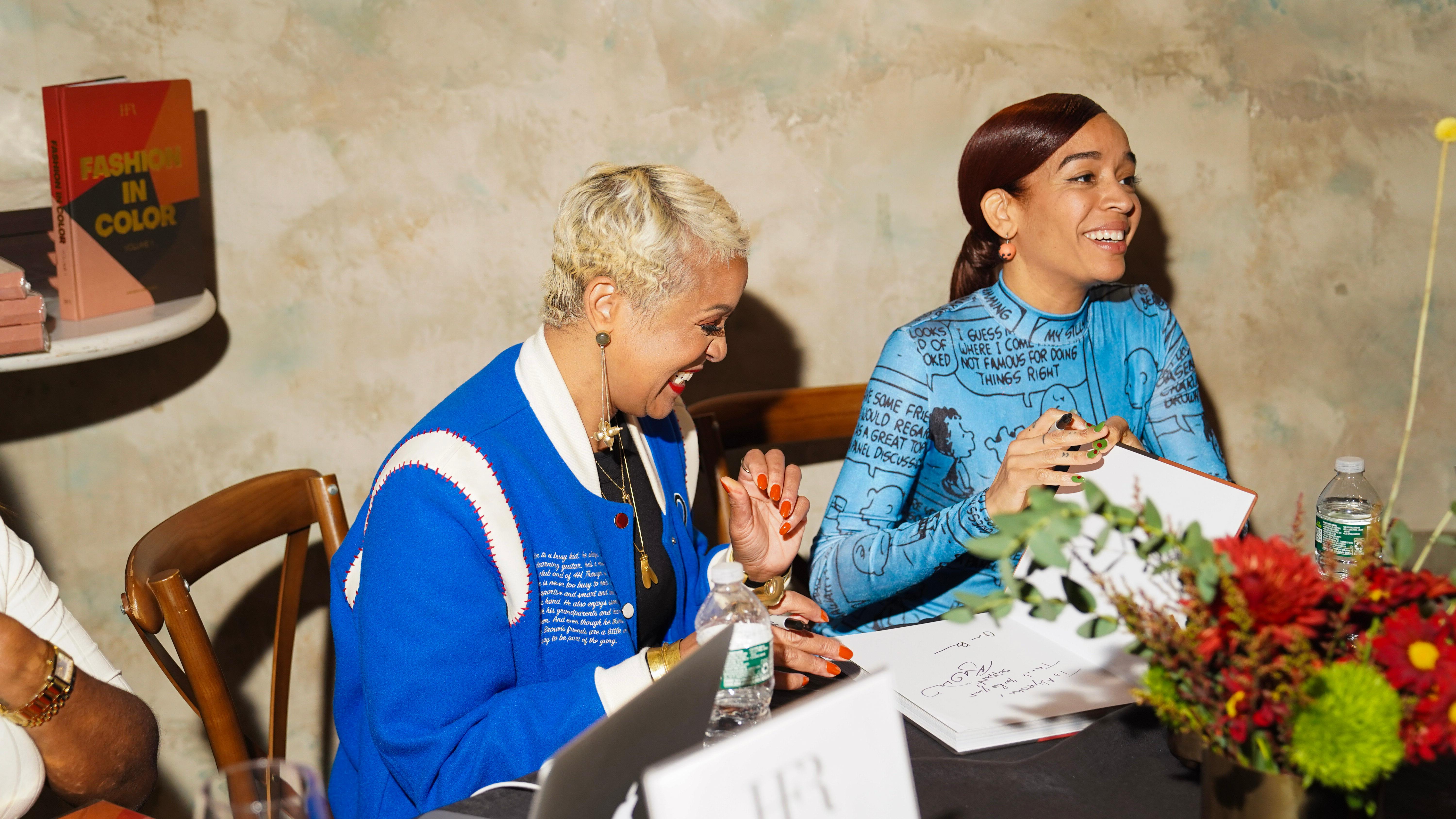 Harlem's Fashion Row founder Brandice Daniel and artist Ashley Buttercup autograph the book "Fashion in Color"