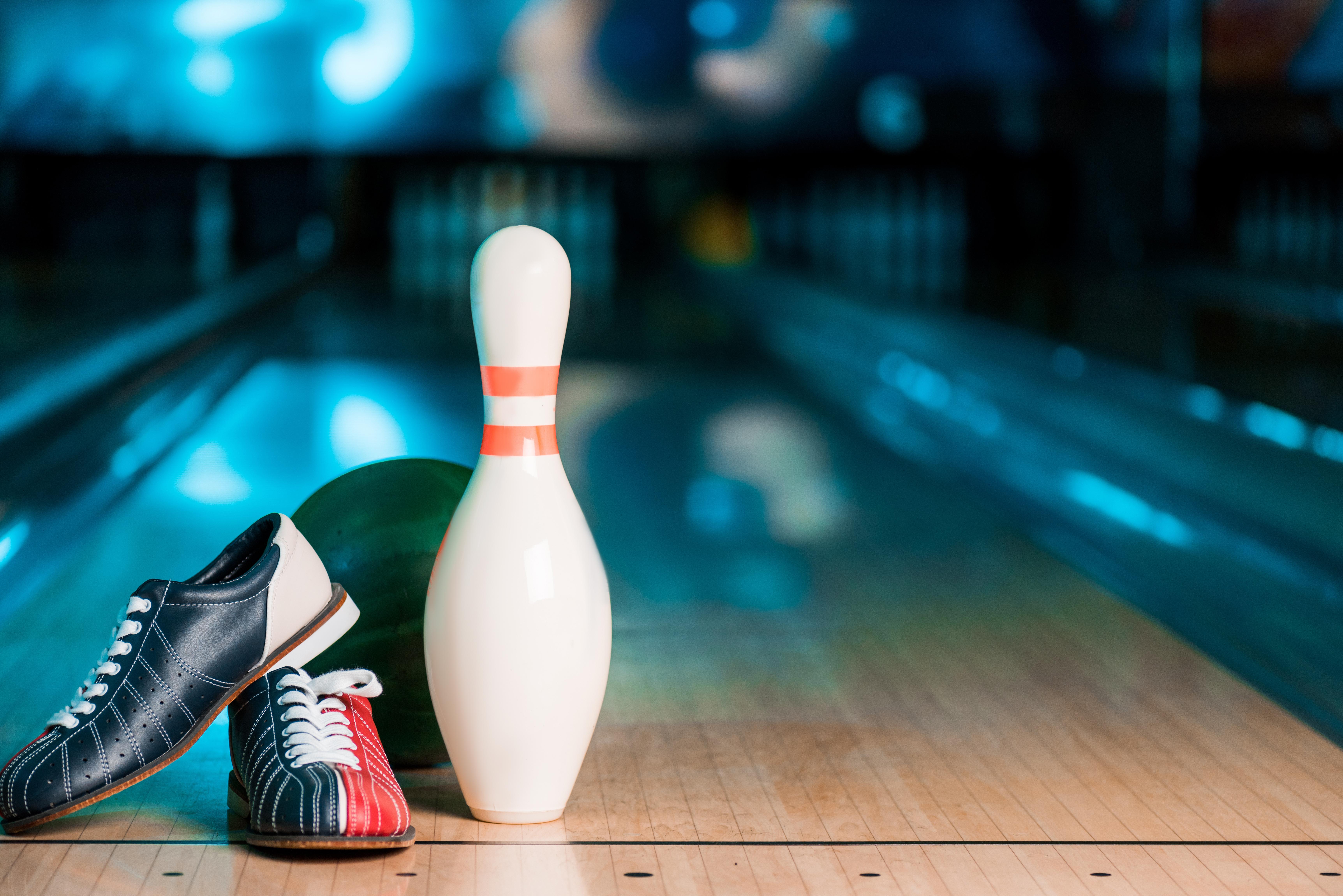 Bowling shoes, a bowling ball and a pin on an alley
