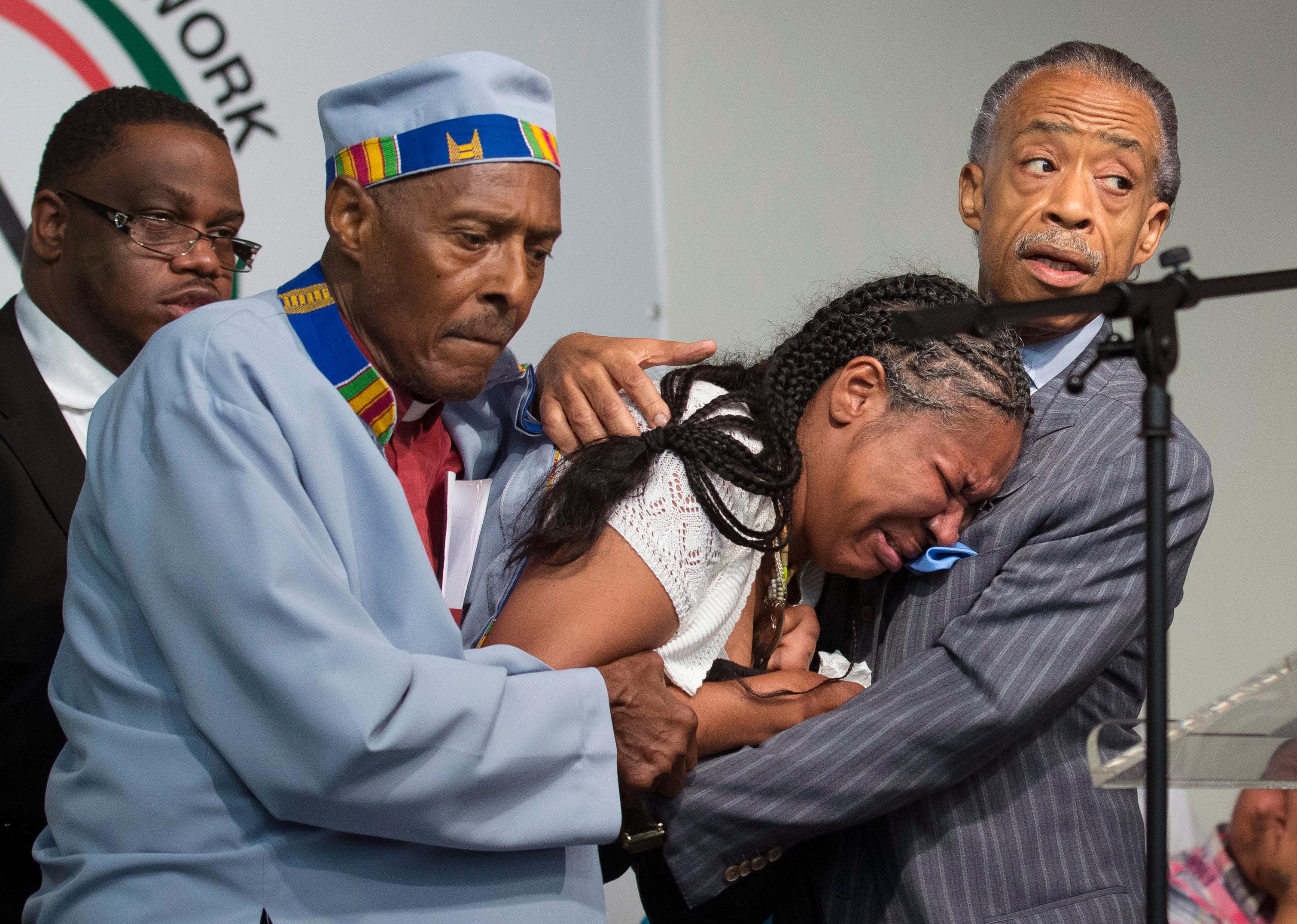 Esaw Garner, wife of Eric Garner, breaks down in the arms of Reverend Herbert Daughtry and Reverend Al Sharpton