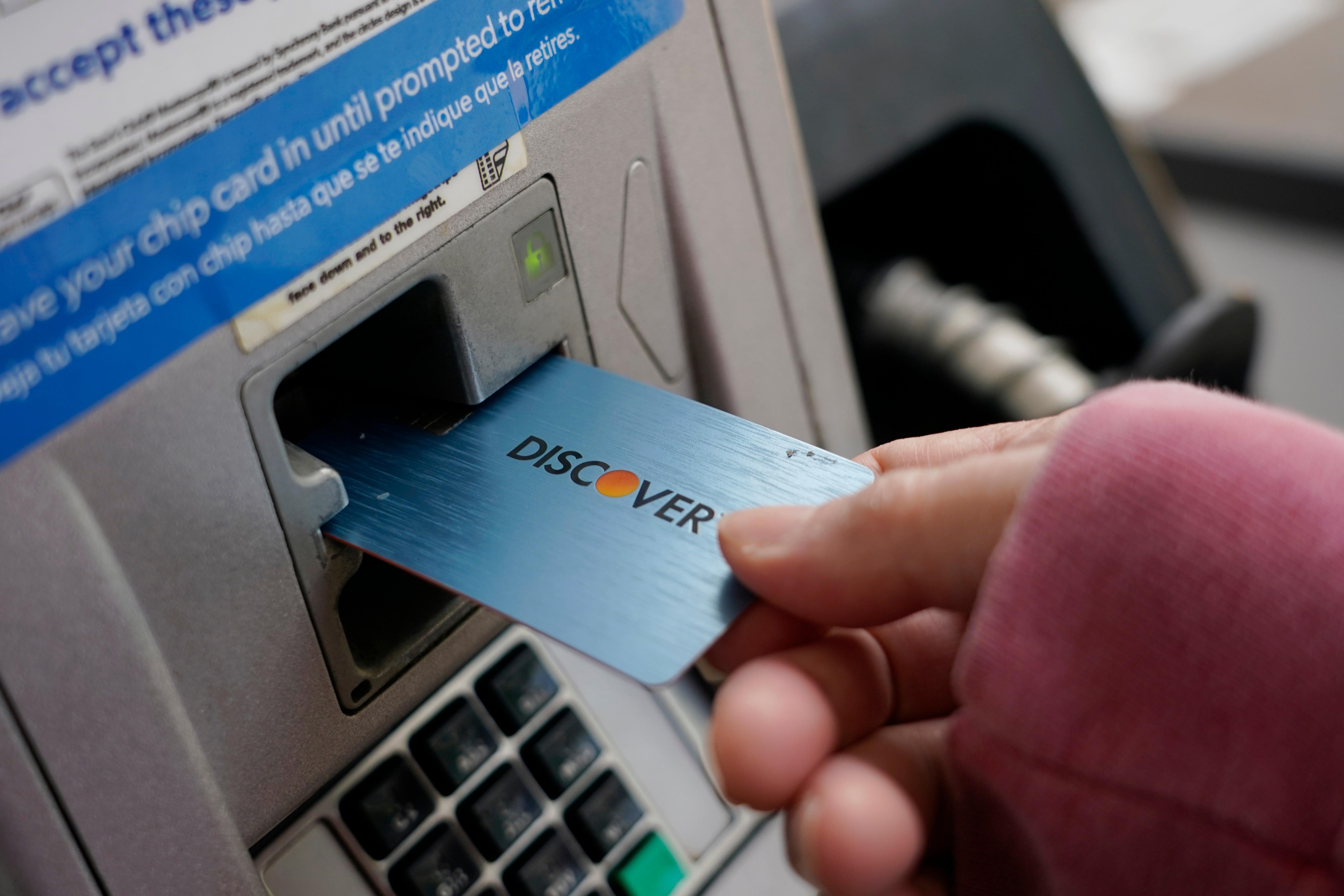A Discover card being inserted into a gas pump