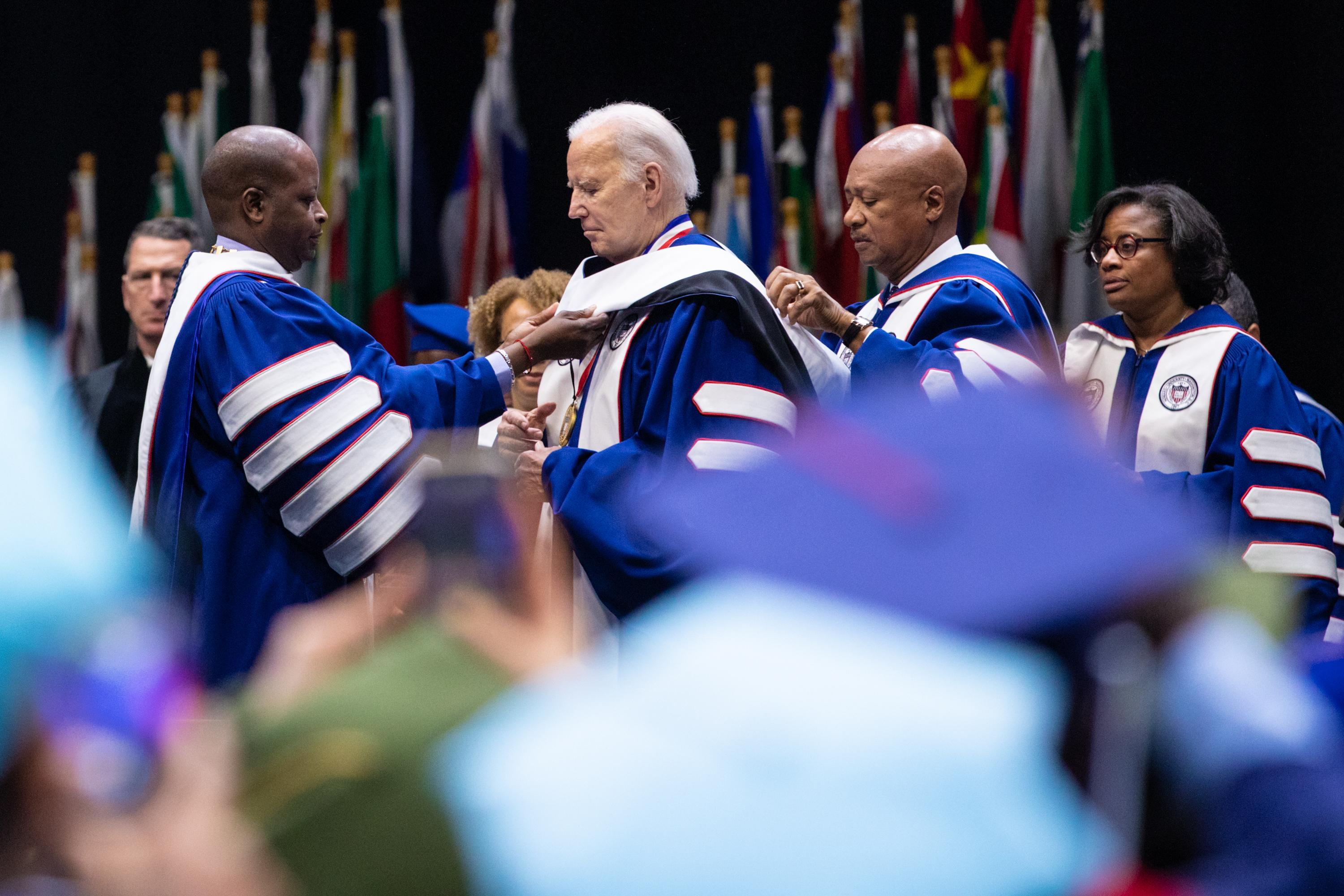 President Joe Biden, wearing a blue graduate gown, receiving an honorary Doctor of Humane Letters