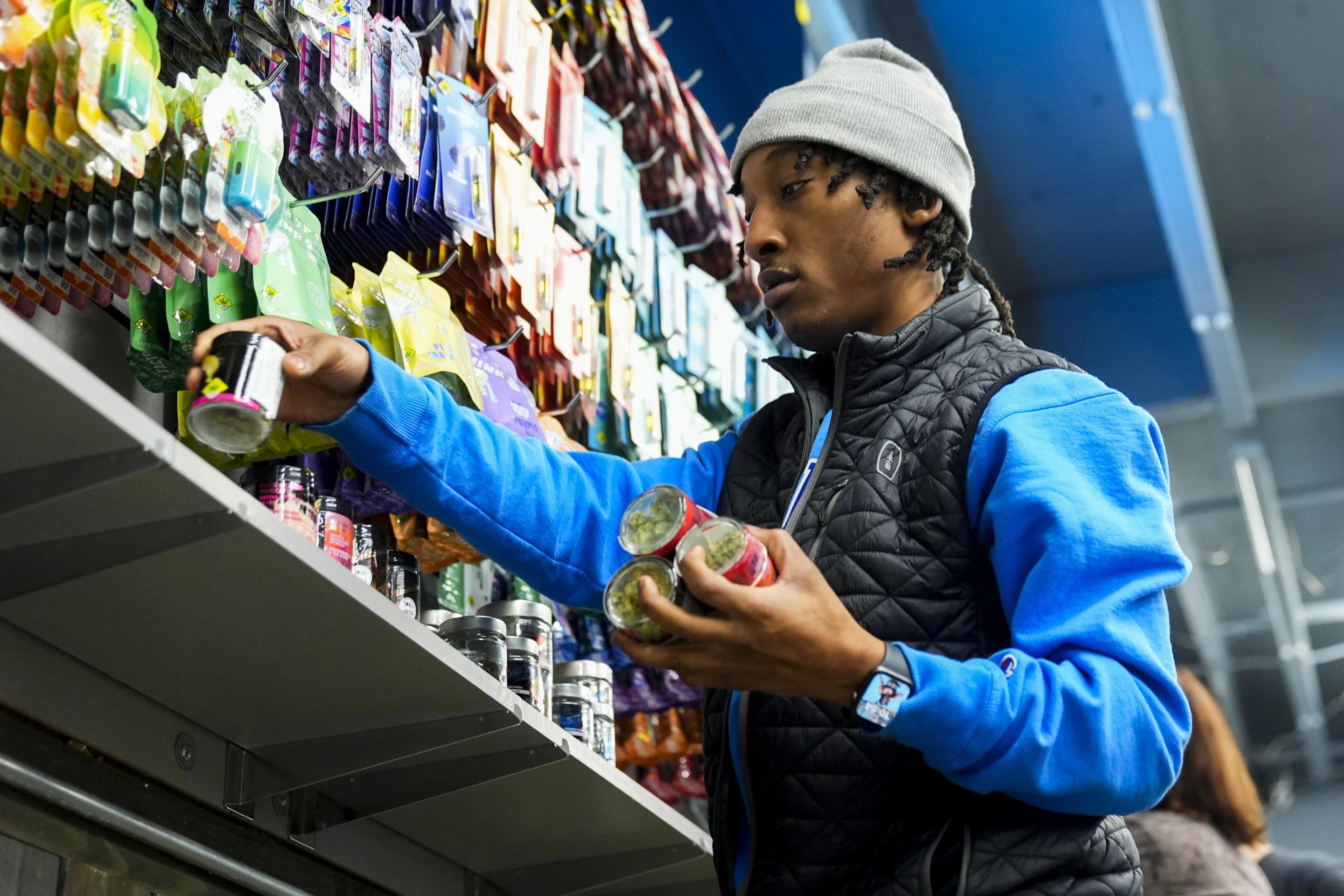Operational lead Willie Morrow stocks shelves at Cloud 9 Cannabis