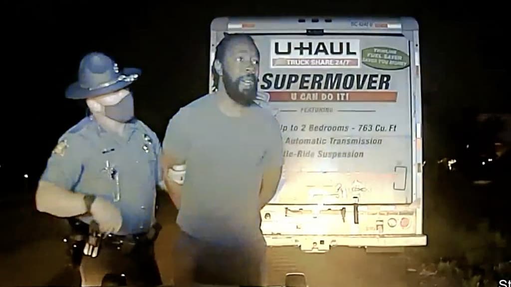 Marion Humphrey Jr., handcuffed and held by a state trooper