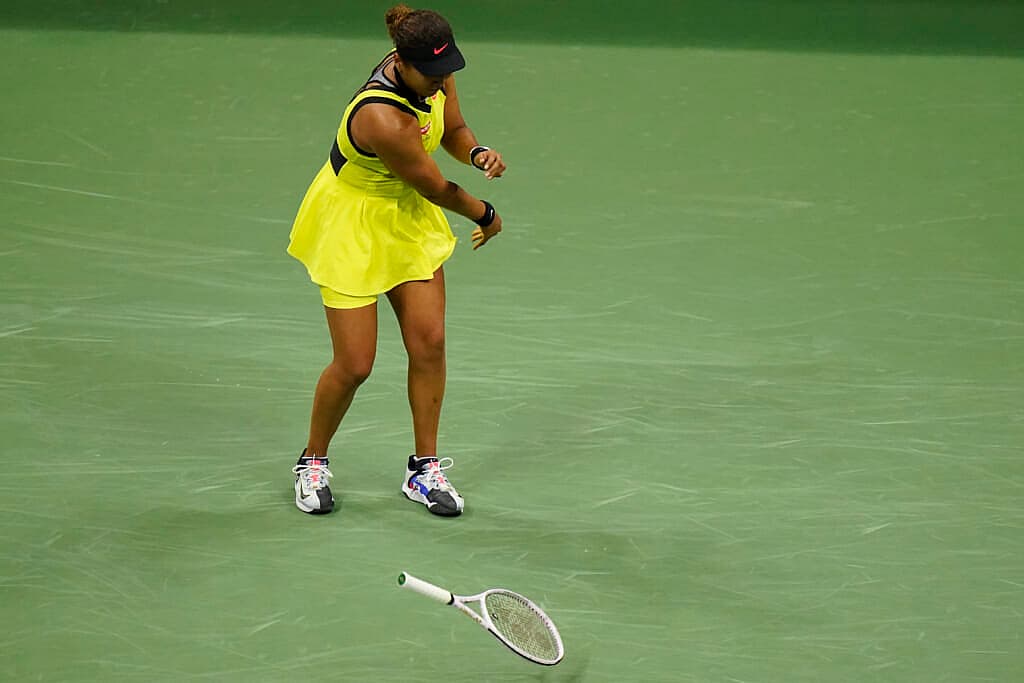 Tennis player Naomi Osaka throws her racket down during a match