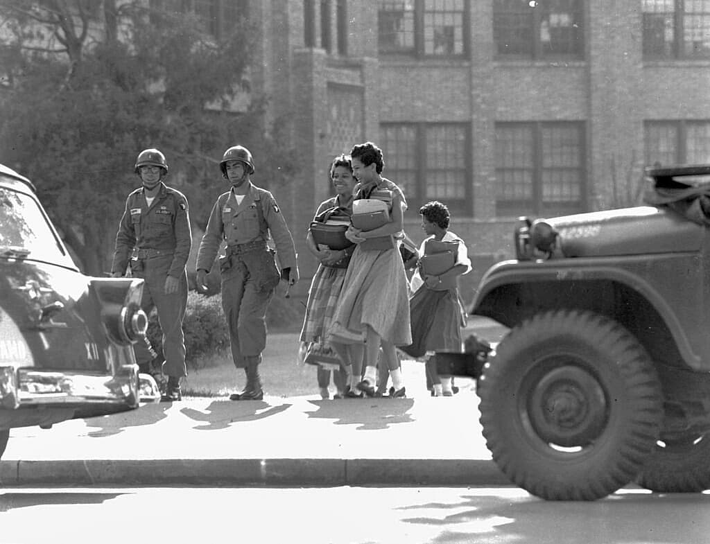 Two paratrooper officers escort black students
