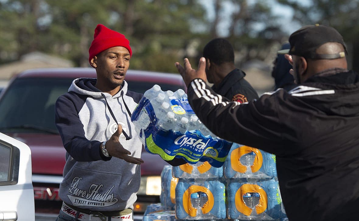 Dontavious Spann and Preston Alston toss cases of water