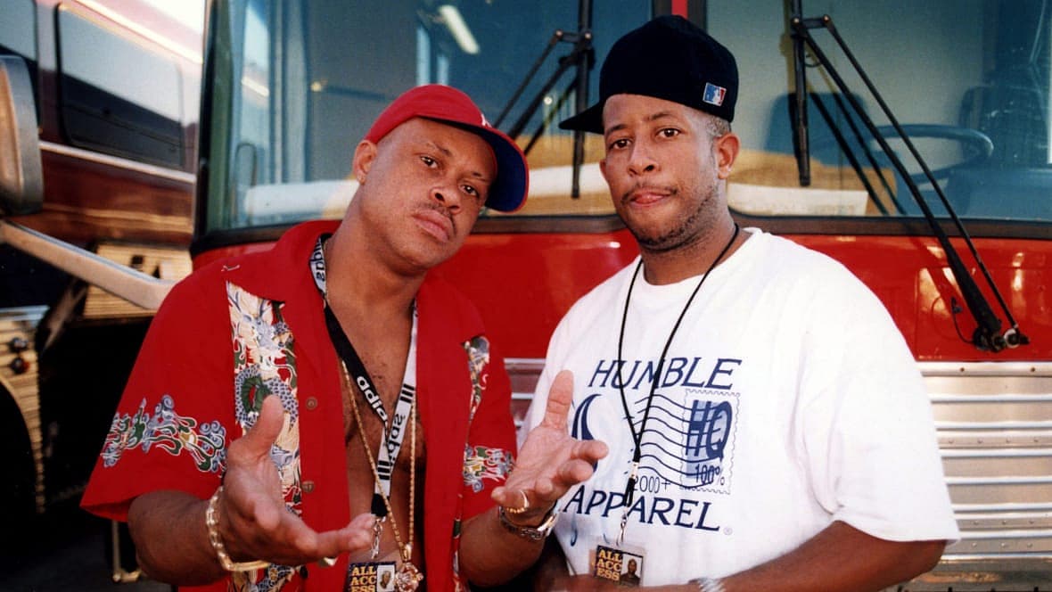 Gang Starr members Guru (Keith Edward Elam) and DJ Premier (Christopher Edward Martin) stand in front of their tour bus