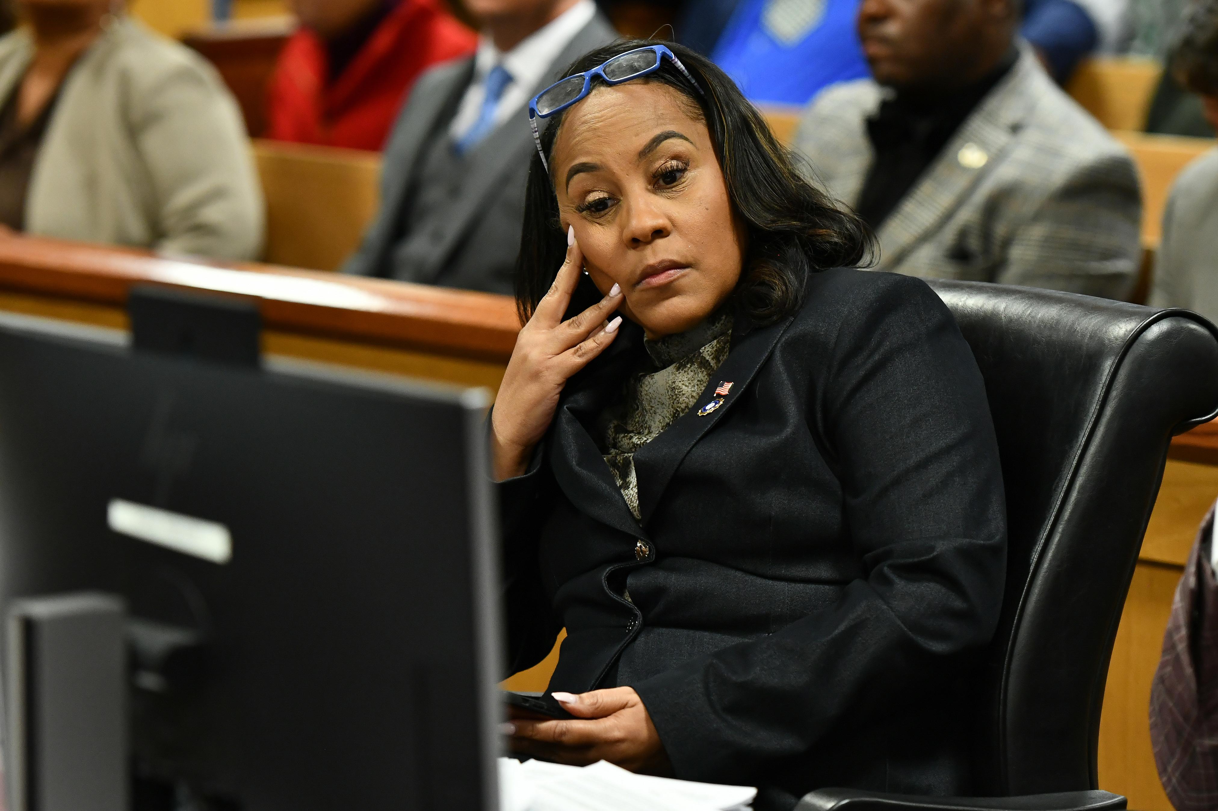 Fulton County District Attorney Fani Willis, seated