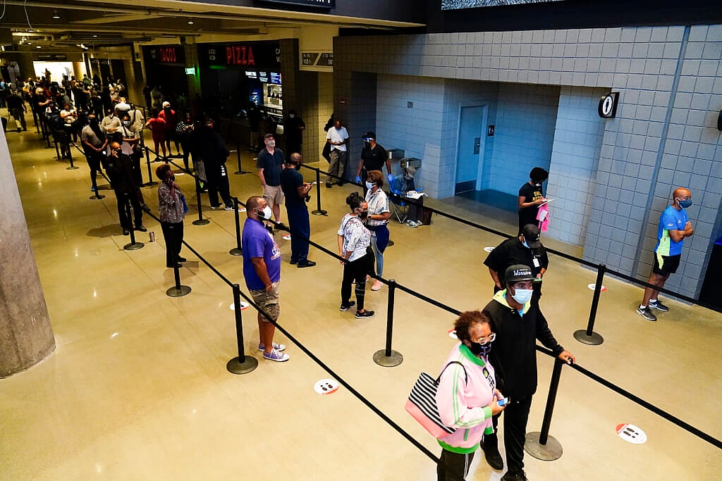 People wait in line to vote early at the State Farm Arena
