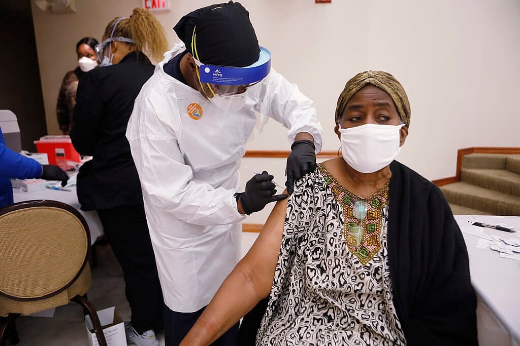 A health care worker administers the COVID-19 vaccine
