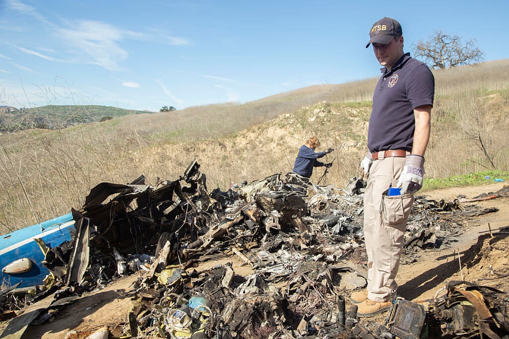 NTSB investigators Carol Hogan and Adam Huray examine wreckage