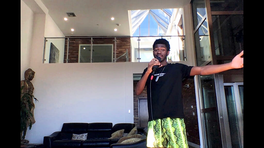 Lil Nas X holding a microphone and gesturing