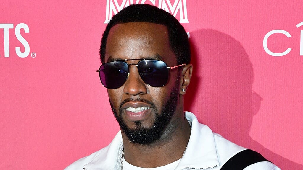 Sean Love "Diddy" Combs wearing a white jacket and sunglasses