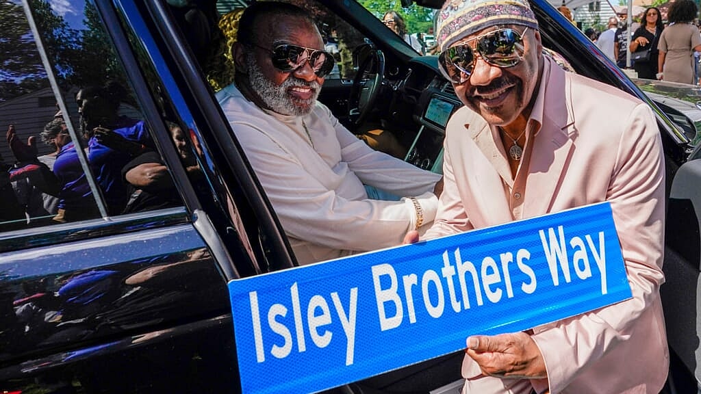 Ron and Ernie Isley pose for a photo with the street sign dedicated to them