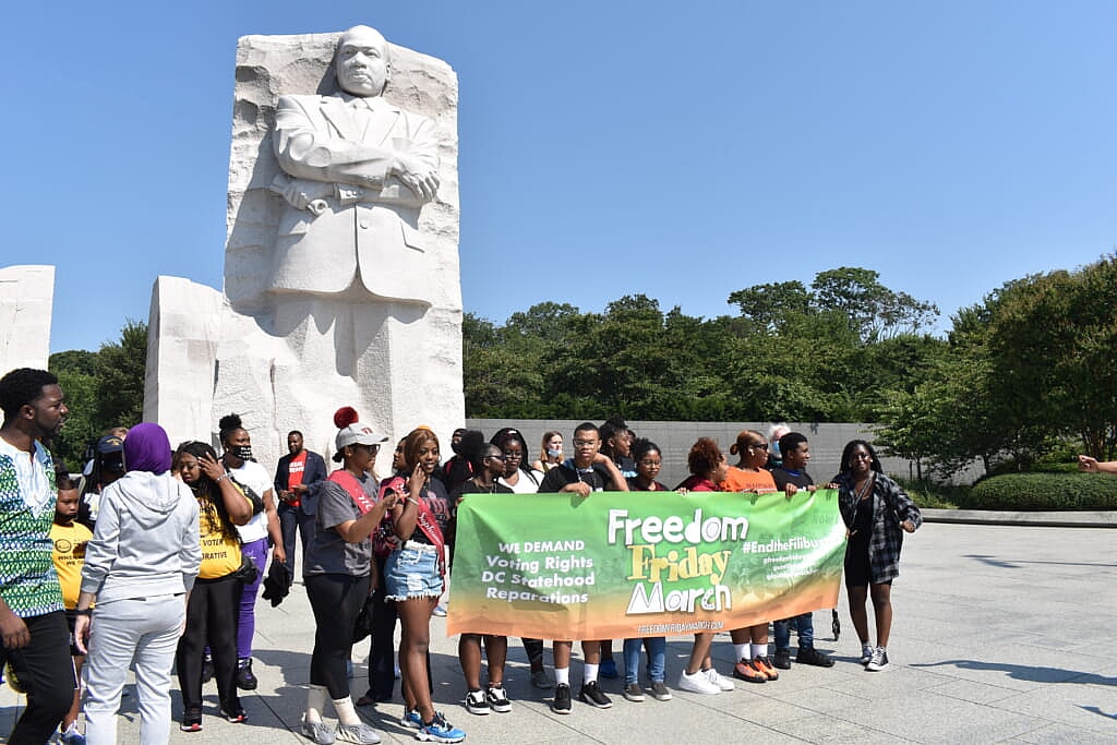 Voting rights demonstrators gather at Dr. Martin Luther King Jr. memorial statue. (Photo: Marconja Zor)