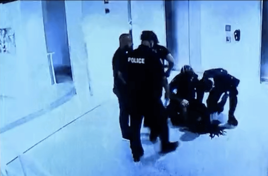 Dalonta Crudup on the ground with several police officers