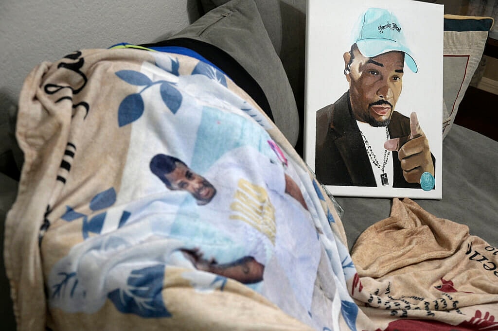 A blanket and painting bearing the likeness of Ronald Greene