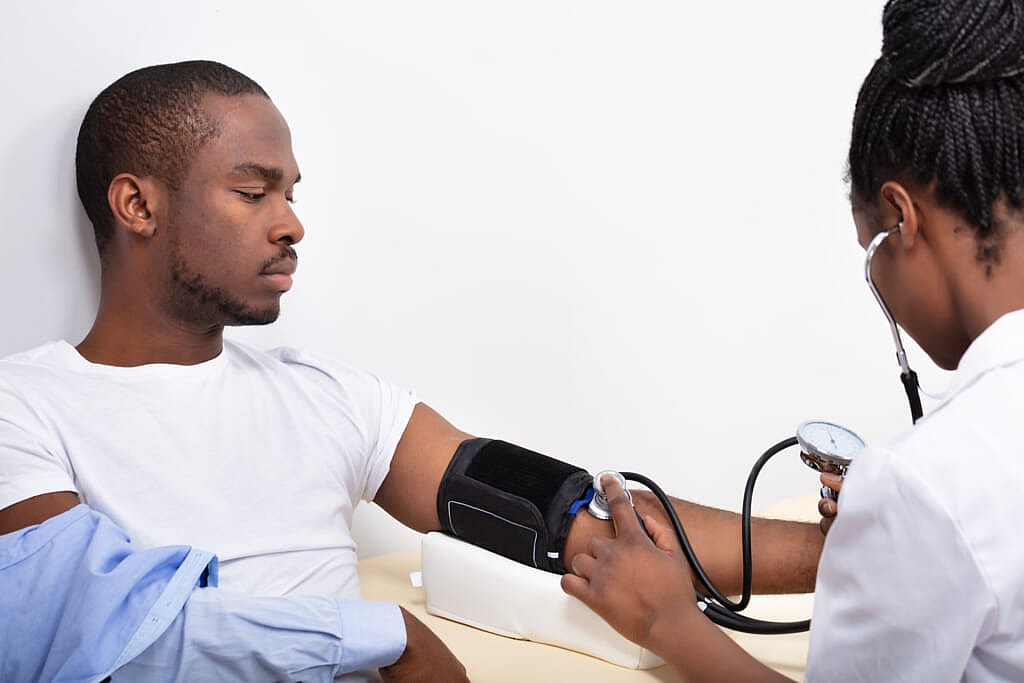 A doctor takes a man's blood pressure