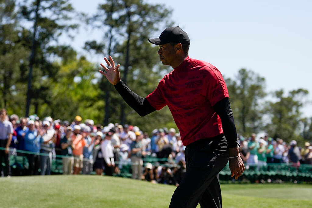 Golfer Tiger Woods waves to spectators