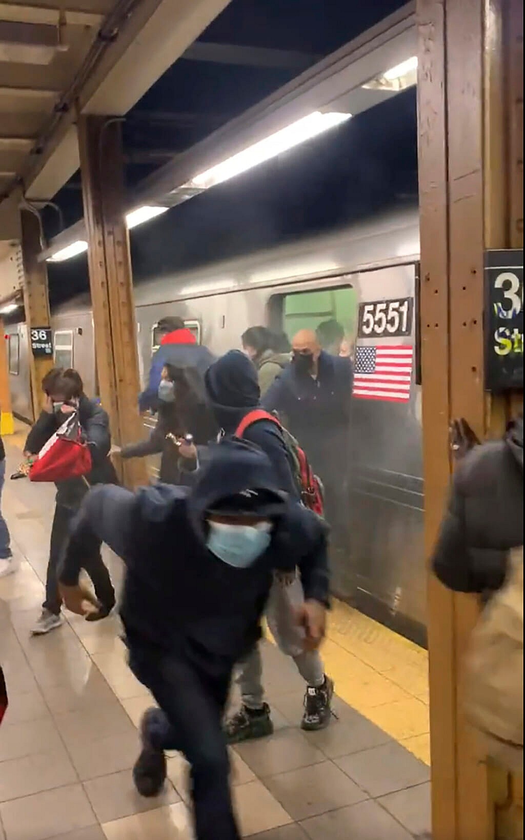 Passengers run from a subway car