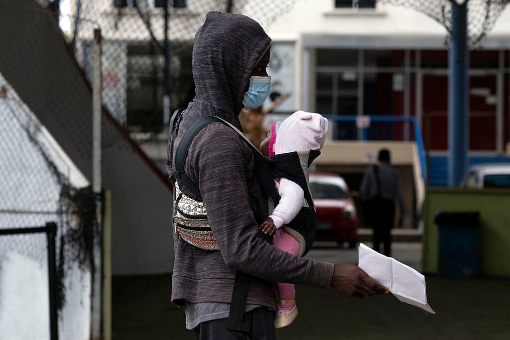 Haitian migrants prepare their papers to register with the National Commission for Refugees