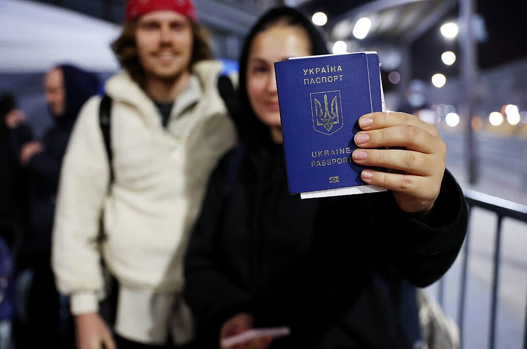 Ukrainian Sasha, who is seeking asylum in the U.S., displays her passport