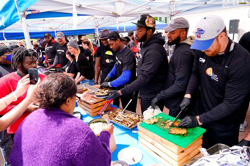 Buffalo Bills players serve food at a World Central Kitchen tent