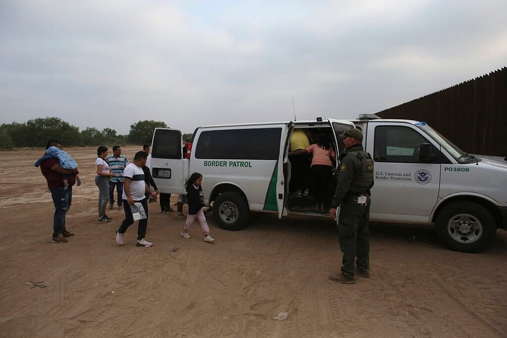 Migrants who had crossed the Rio Grande river into the U.S. are taken away by U.S. Border Patrol agents