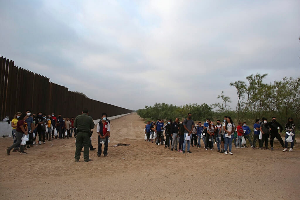A Border Patrol agent instructs migrants