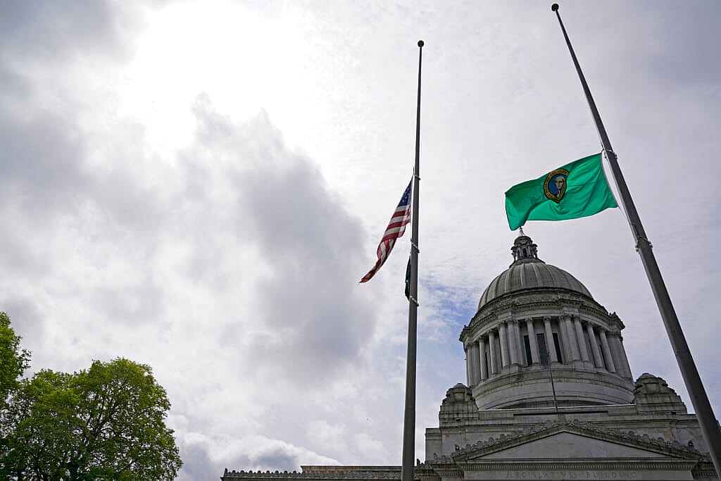 The U.S. and Washington state flags fly at half-staff in front of the Legislative Building