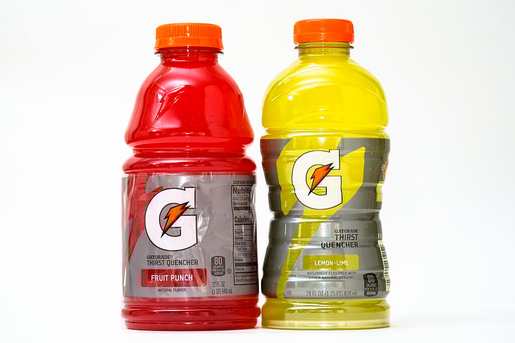 A 32-ounce bottle of red Gatorade is shown beside a differently shaped bottle of yellow Gatorade holding 28 ounces