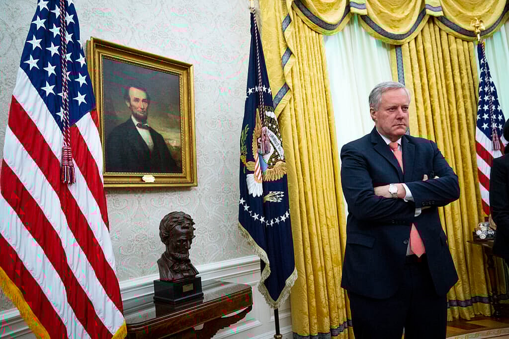 White House Chief of Staff Mark Meadows stands with arms folded near a portrait of Abraham Lincoln