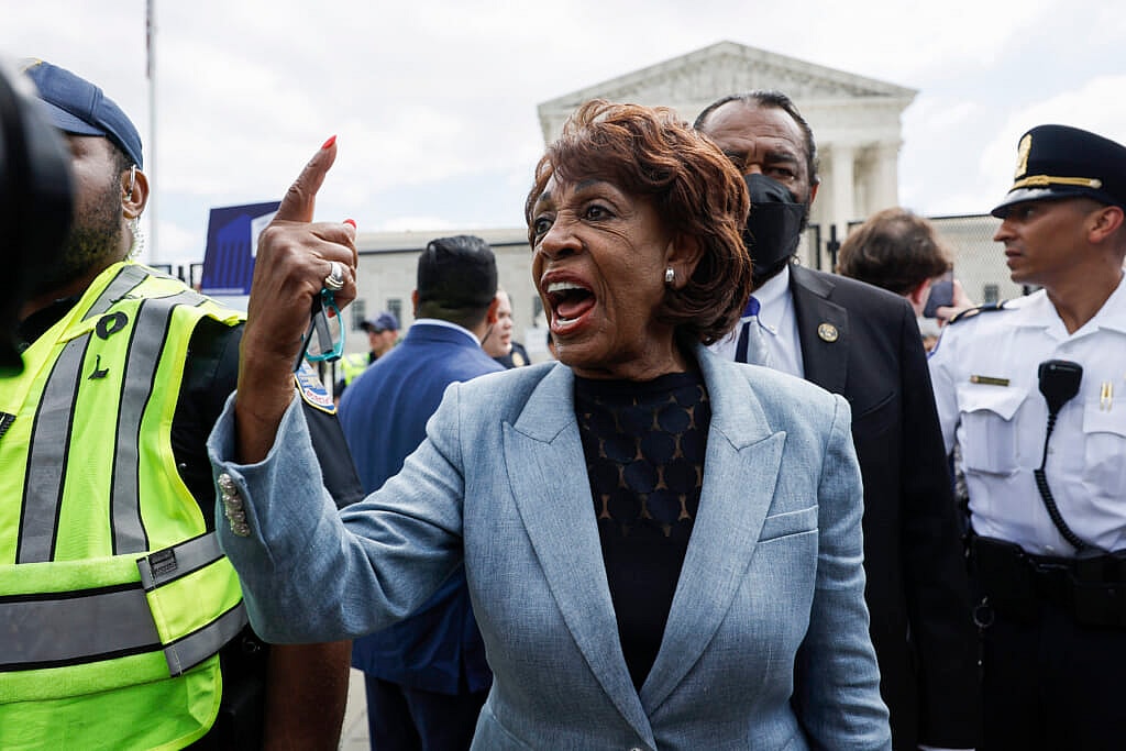 Democratic Representative Maxine Waters of California gestures, wearing a light blue jacket and dark shirt