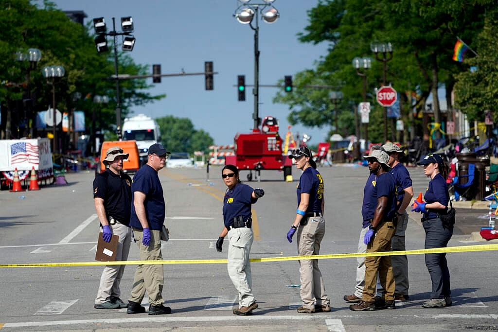 FBI personnel stand near crime scene tape in the middle of a street