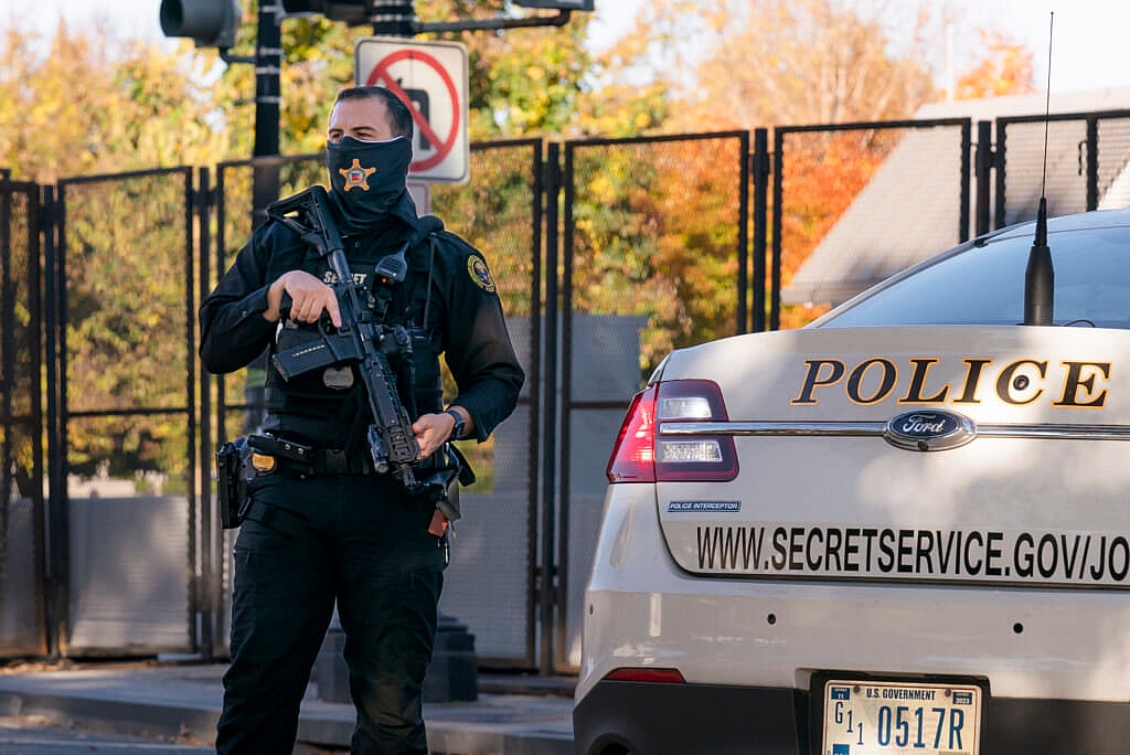 A Secret Service officer near a police car