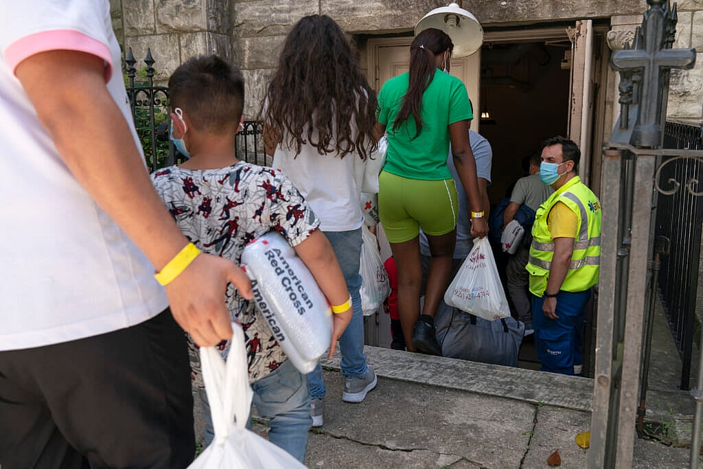 Orlando Andara and Derick Alegria greet people seeking asylum