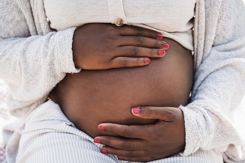 Close-up of Black pregnant woman holding her belly
