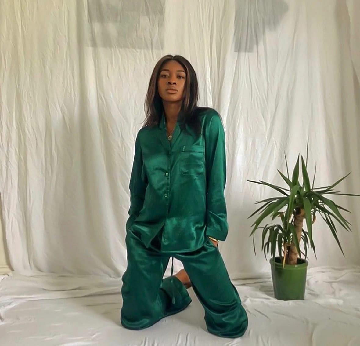 A woman wearing green silk pajamas