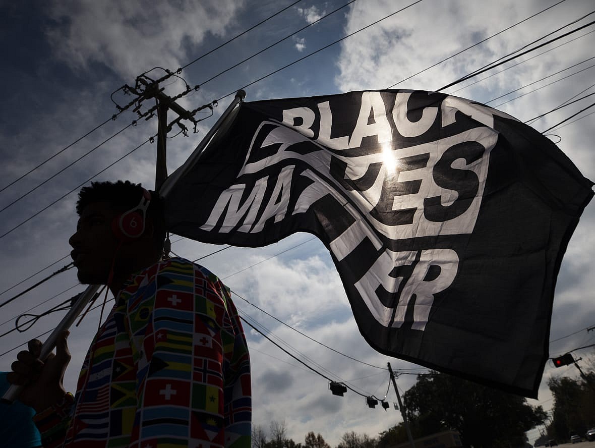 A person carrying a Black Lives Matter flag