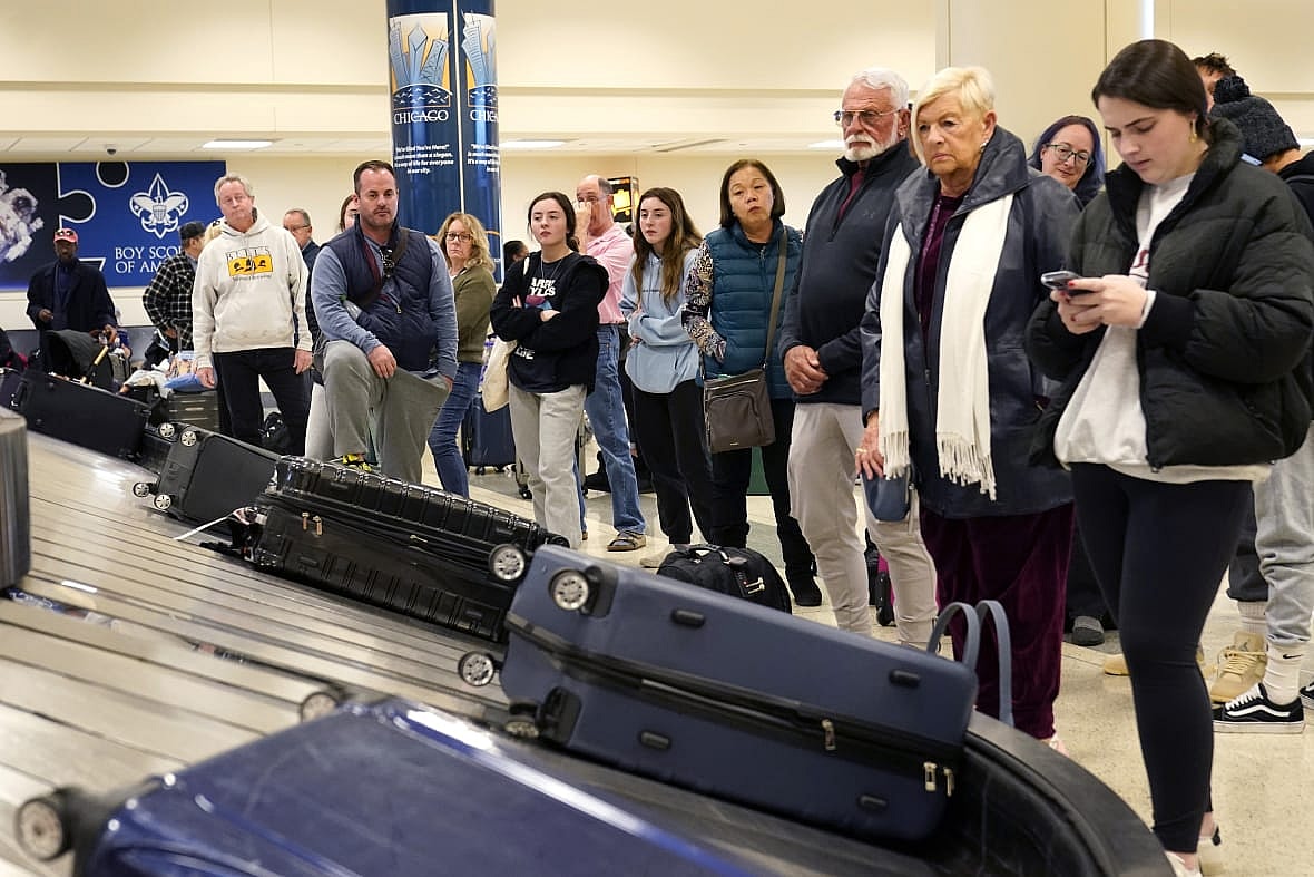 Passengers arriving at Chicago’s Midway Airport wait for their luggage