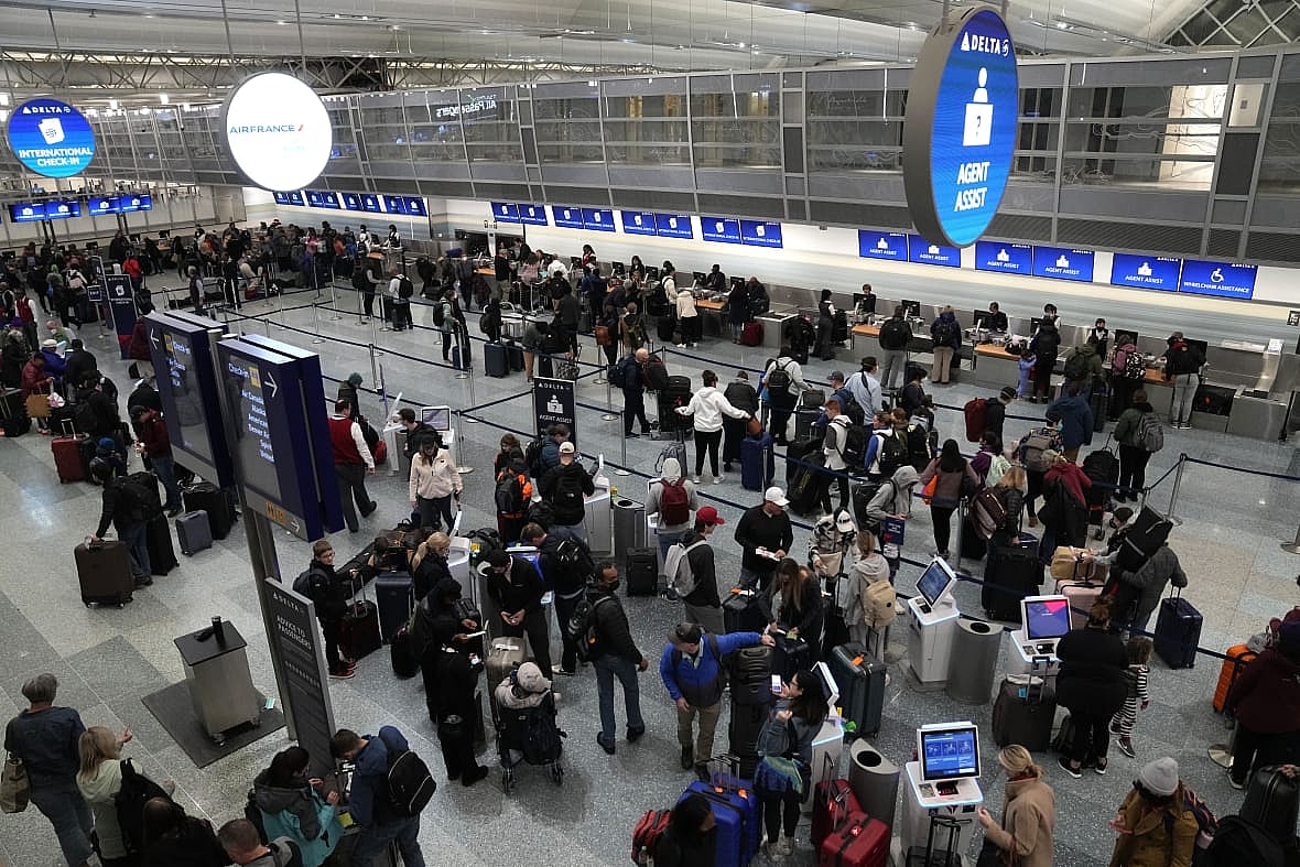 Travelers check in at kiosks and wait in line to check luggage at Minneapolis-St. Paul Airport