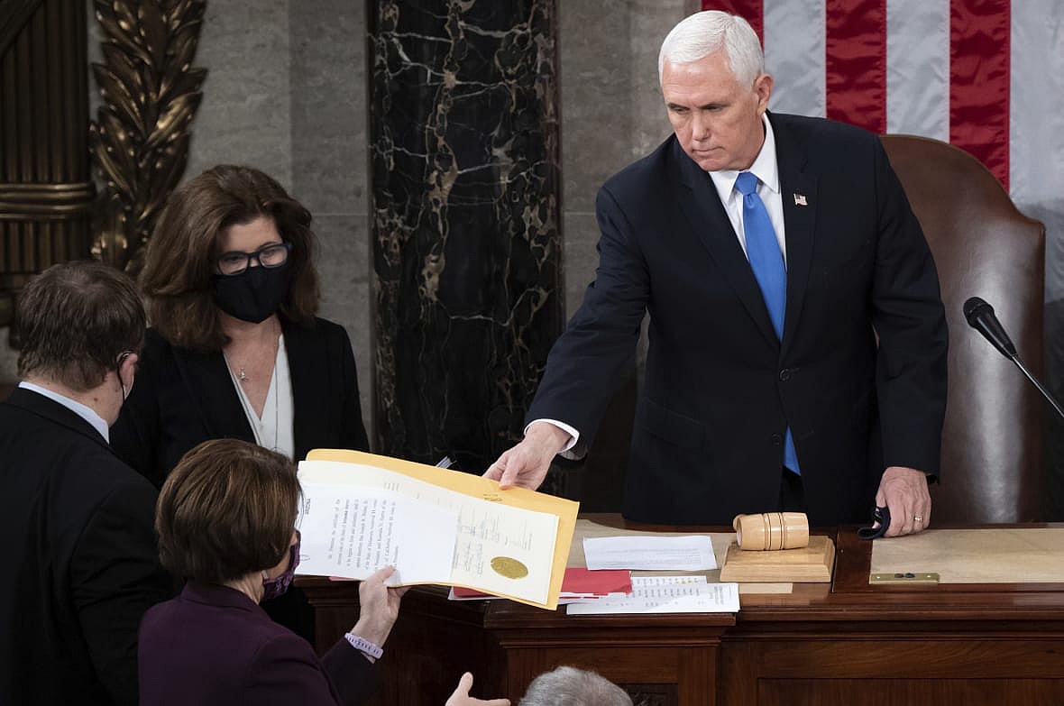 Former Vice President Mike Pence hands an electoral certificate to Democratic Senator Amy Klobuchar of Minnesota