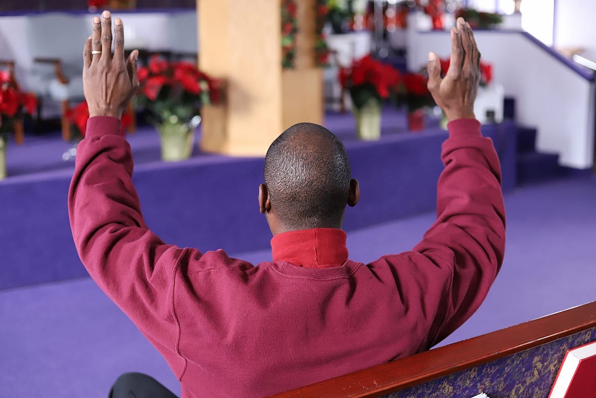 A man raises his arms in a church