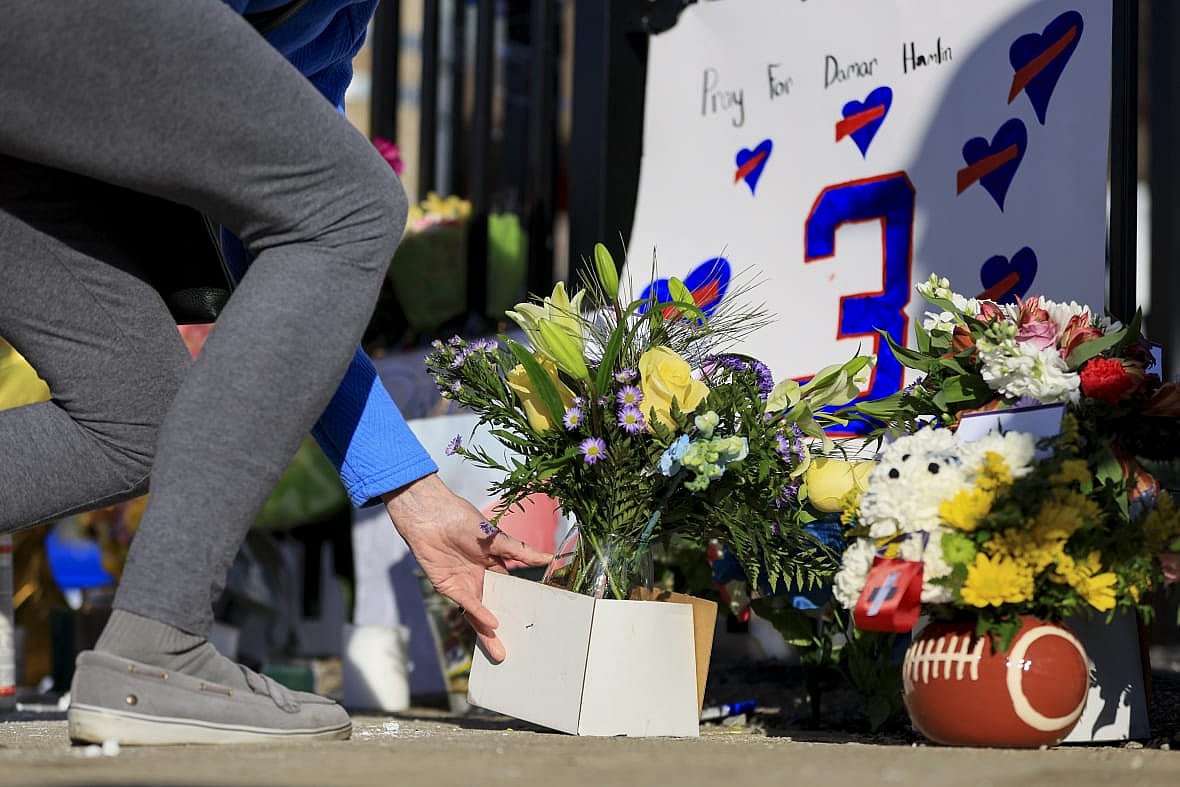 A person leaves flowers for the display set up for Buffalo Bills’ Damar Hamlin