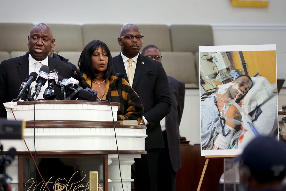 Civil rights attorney Ben Crump, Rodney and RowVaughn Wells, stepfather and mother of Tyre Nichols, next to his photo