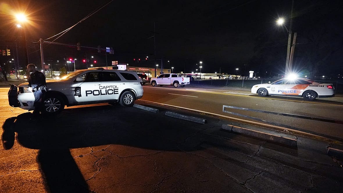 Officers from the state-run Capitol Police and the city-run Jackson Police Department stand watch outside a church