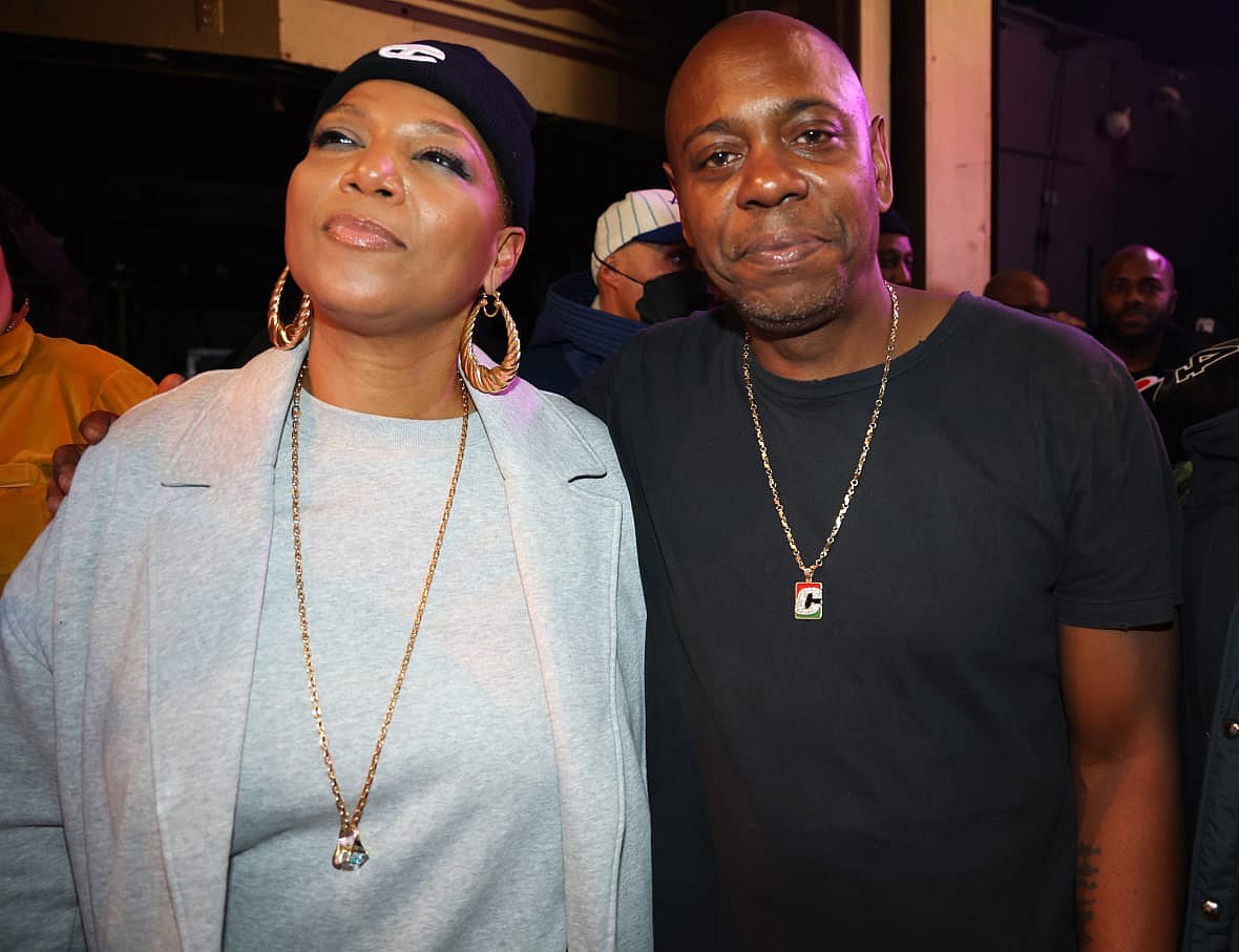 Musician and actor Queen Latifah, wearing a gray shirt and jacket, and comedian Dave Chappelle, wearing a black shirt